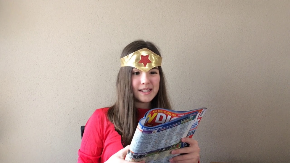 Mädchen mit Stirnband liest eine Zeitschrift